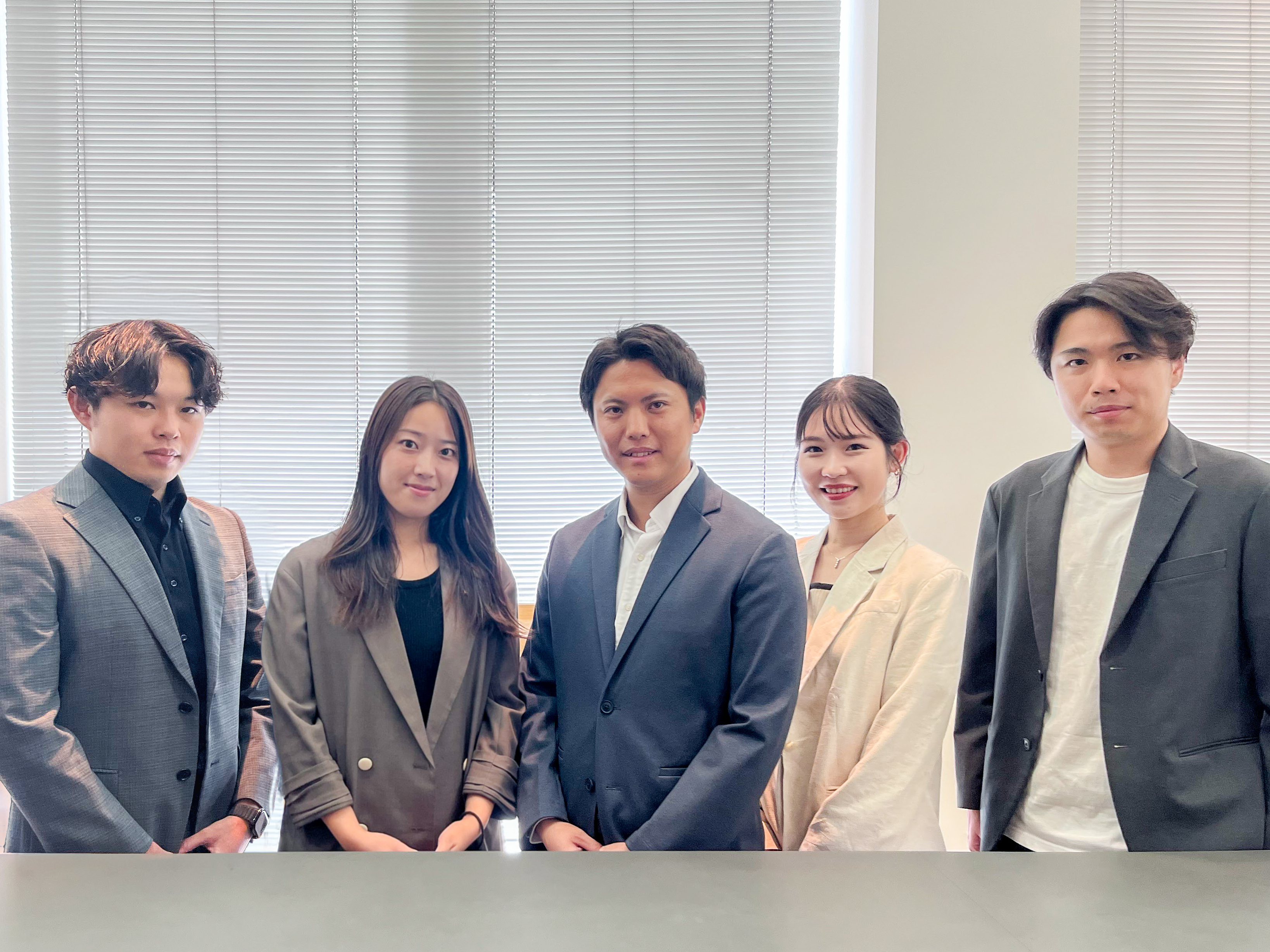 営業職の男女5名が並ぶ集合写真