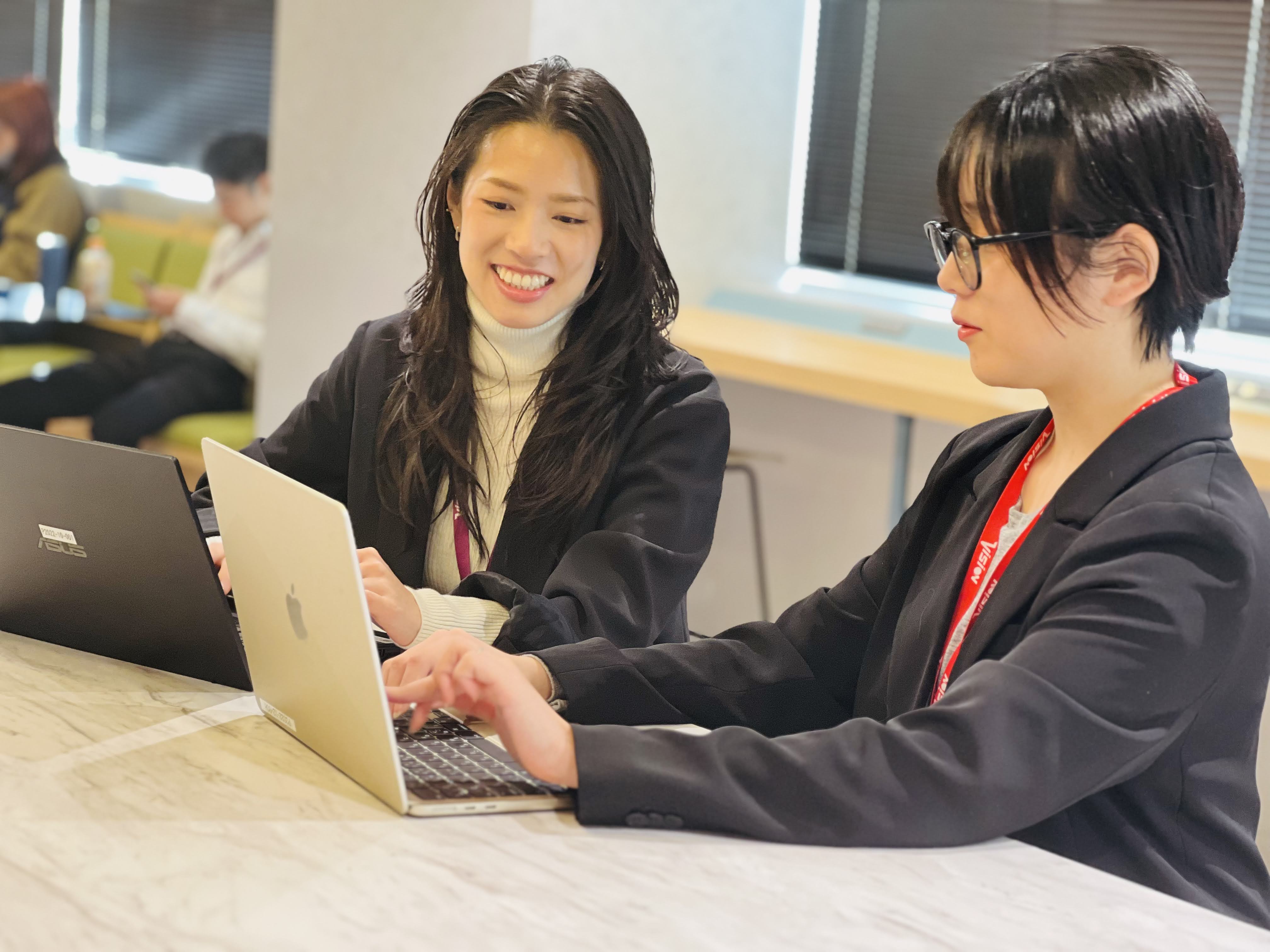 隣り合ってPC作業をするWEBディレクターの女性2人